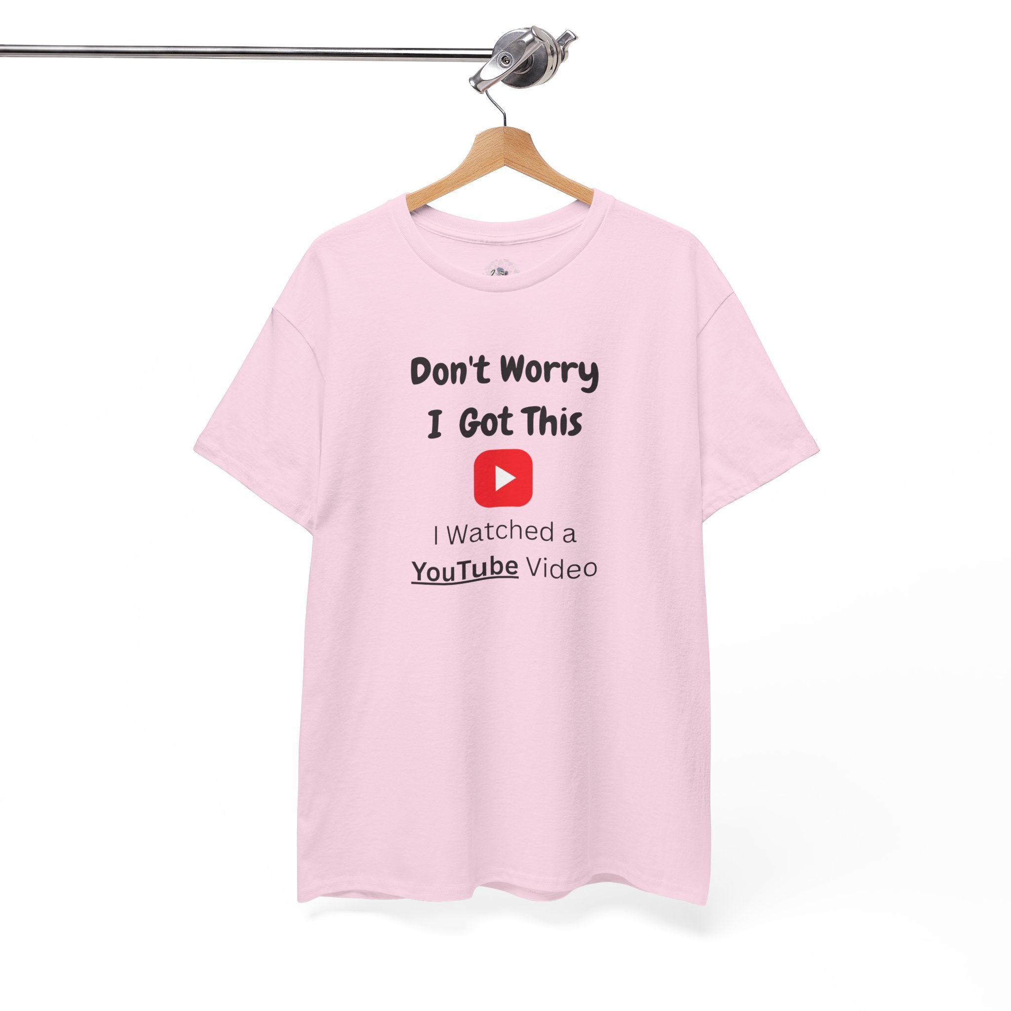 Pink t-shirt with humorous text design on a hanger against a white background