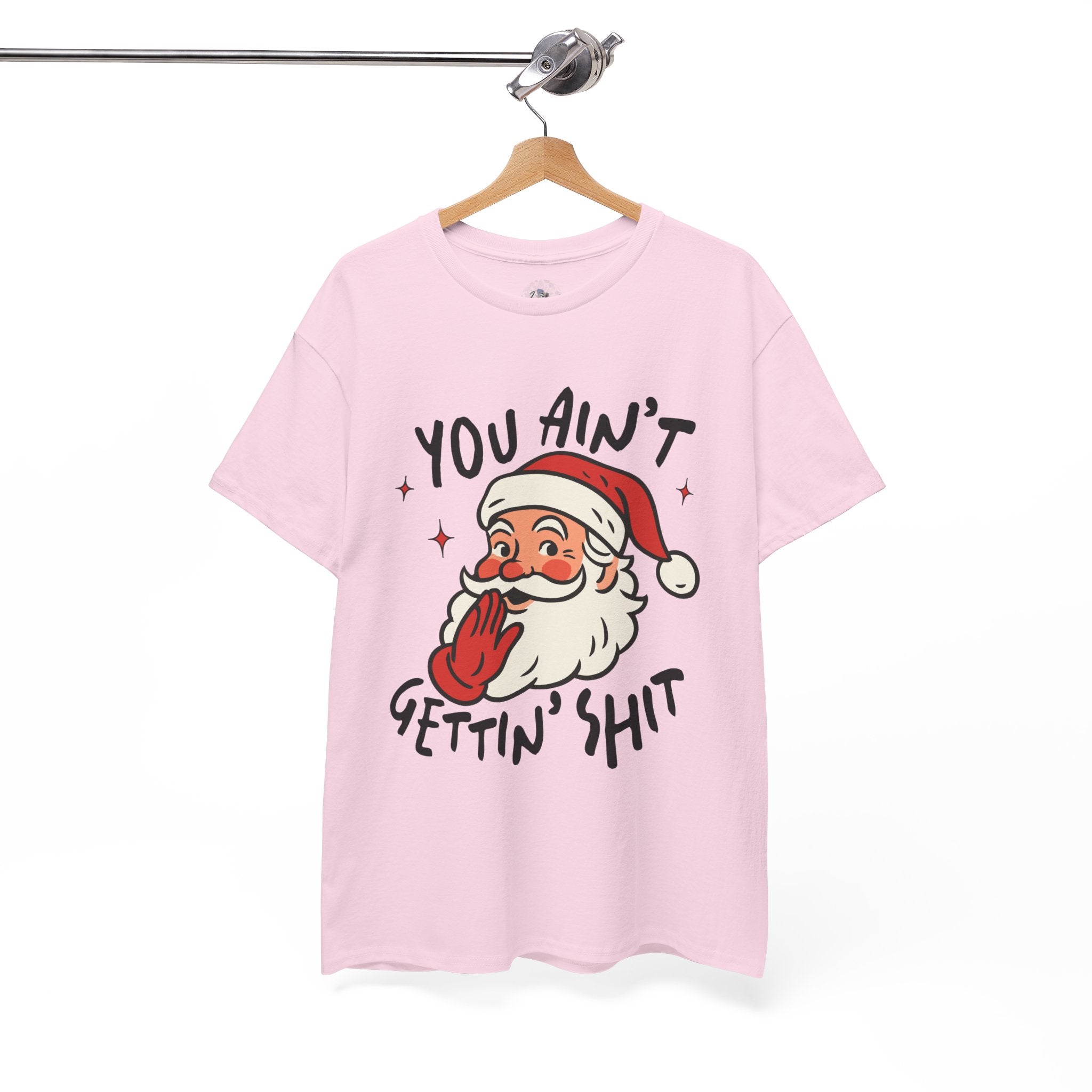 Pink t-shirt with a graphic of Santa Claus and funny rude on a hanger against a white background