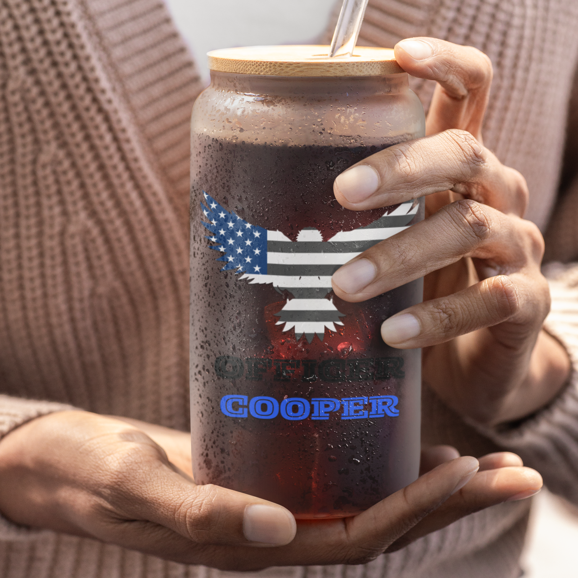 Person holding a personalized black and blue tumbler with an American flag design.