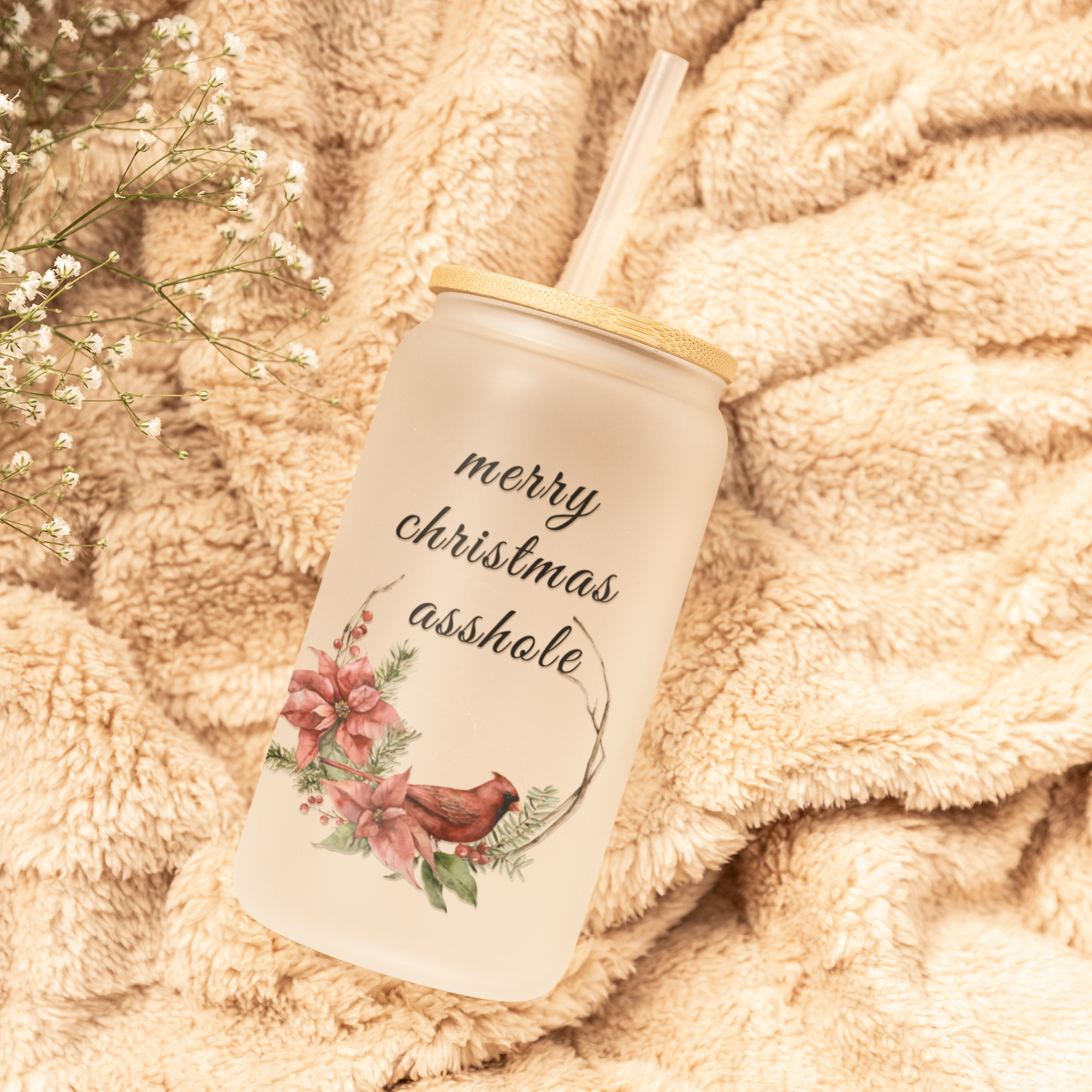 Tumbler with 'merry christmas asshole' design on a soft, beige fabric background