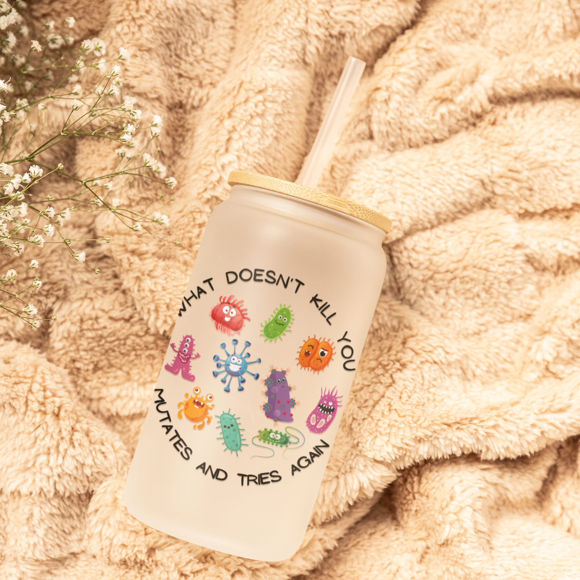 Tumbler with colorful illustrations and text on a soft, beige fabric background