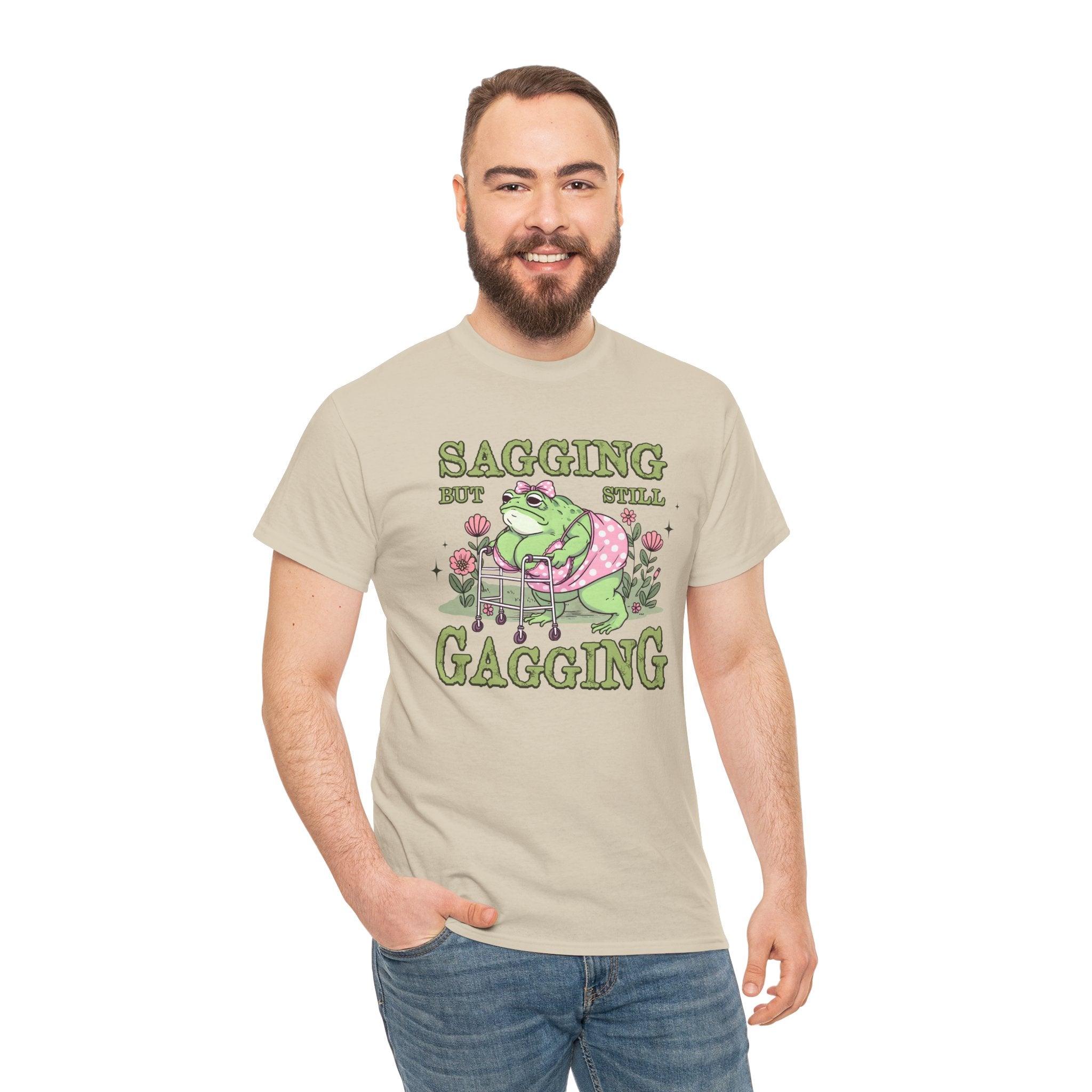 Man wearing a sand colored t-shirt with faunny frog design on a white background